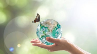 γυάλινη σφαίρα της γης, πεταλούδα, χέρια
