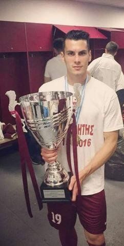 Ο Δημήτρης Καππός στα αποδυτήρια του ΑΕΛ FC Arena, μετά το νικηφόρο παιχνίδι της προτελευταίας αγωνιστικής με τα Χανιά, όπου έγινε η φιέστα για την άνοδο της ομάδας στη Σούπερ Λίγκα, κρατώντας το κύπελλο που απονεμήθηκε στη θεσσαλική ομάδα.