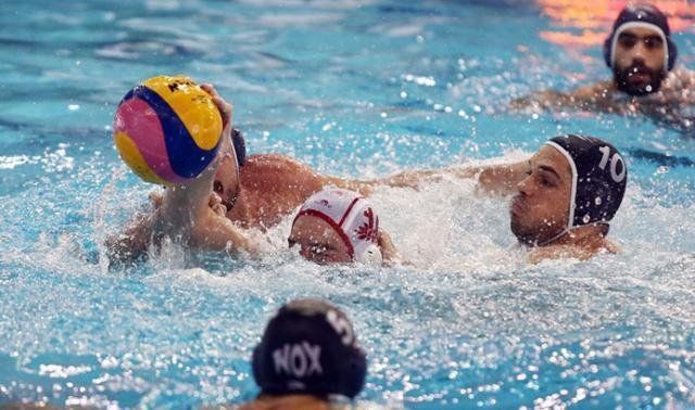 Από το σαββατιάτικο παιχνίδι του ΝΟΧ στον Πειραιά με τον Ολυμπιακό. Διακρίνεται ο Γιώργος Φουντούλης σε μια διεκδίκηση της μπάλας με τον Γούνα, ενώ παρακολουθούν οι Μιμίδης, Πρέκας, Βιτέλας.