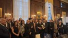 Σύσσωμη η ομάδα των παραγωγών του «Cosmos FM» και του Διοικητικού Συμβουλίου του Ιδρύματος GAEPIS με το ζεύγος Αγγελικής και Στέλιου Ζερβούδη, ενώ διακρίνονται ο Αρχιεπίσκοπος Ελπιδοφόρος, η γενική πρόξενος της Ελλάδας, Ιφιγένεια Καναρά, ο γενικός πρόξενο