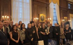 Σύσσωμη η ομάδα των παραγωγών του «Cosmos FM» και του Διοικητικού Συμβουλίου του Ιδρύματος GAEPIS με το ζεύγος Αγγελικής και Στέλιου Ζερβούδη, ενώ διακρίνονται ο Αρχιεπίσκοπος Ελπιδοφόρος, η γενική πρόξενος της Ελλάδας, Ιφιγένεια Καναρά, ο γενικός πρόξενο