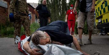 Ο Βίκτορ θρηνεί τη νεκρή γυναίκα του Ναταλία Κολέσνικ, ενώ οι διασώστες περιμένουν να κλείσουν τον νεκρόσακο. Είχε βγει, όπως έκανε κάθε απόγευμα, για να ταΐσει τις γάτες στη γειτονιά της στο Χάρκοβο, όταν οι Ρώσοι άρχισαν να βομβαρδίζουν. [A.P. Photo / E