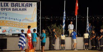 Φωτογραφικό στιγμιότυπο από την απονομή των επάθλων στους τρεις πρώτους νικητές στα Όπτιμιστ στους Βαλκανικούς Αγώνες με την ανάκρουση του εθνικού ύμνου της Τουρκίας για τον 1ο νικητή και τον Φάνη Ζήση στο 2ο σκαλοπάτι του βάθρου τυλιγμένο με την ελληνική σημαία.