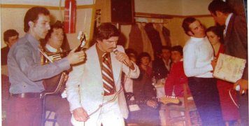 Στο στιγμιότυπο ο Μιχάλης Ιτάλικος με το μπουζούκι του, ο συγχωρεμένος Γιάννης Ζερβούδης στο τραγούδι και άκρη δεξιά ο επίσης συγχωρεμένος Παναγιώτης Στρουμπής.