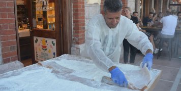 Το τεράστιο λουκούμι μαστίχα κόβεται και μοιράζεται επί τόπου στο κοινό