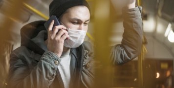 side-view-man-talking-phone-bus-while-wearing-covid-19-mask